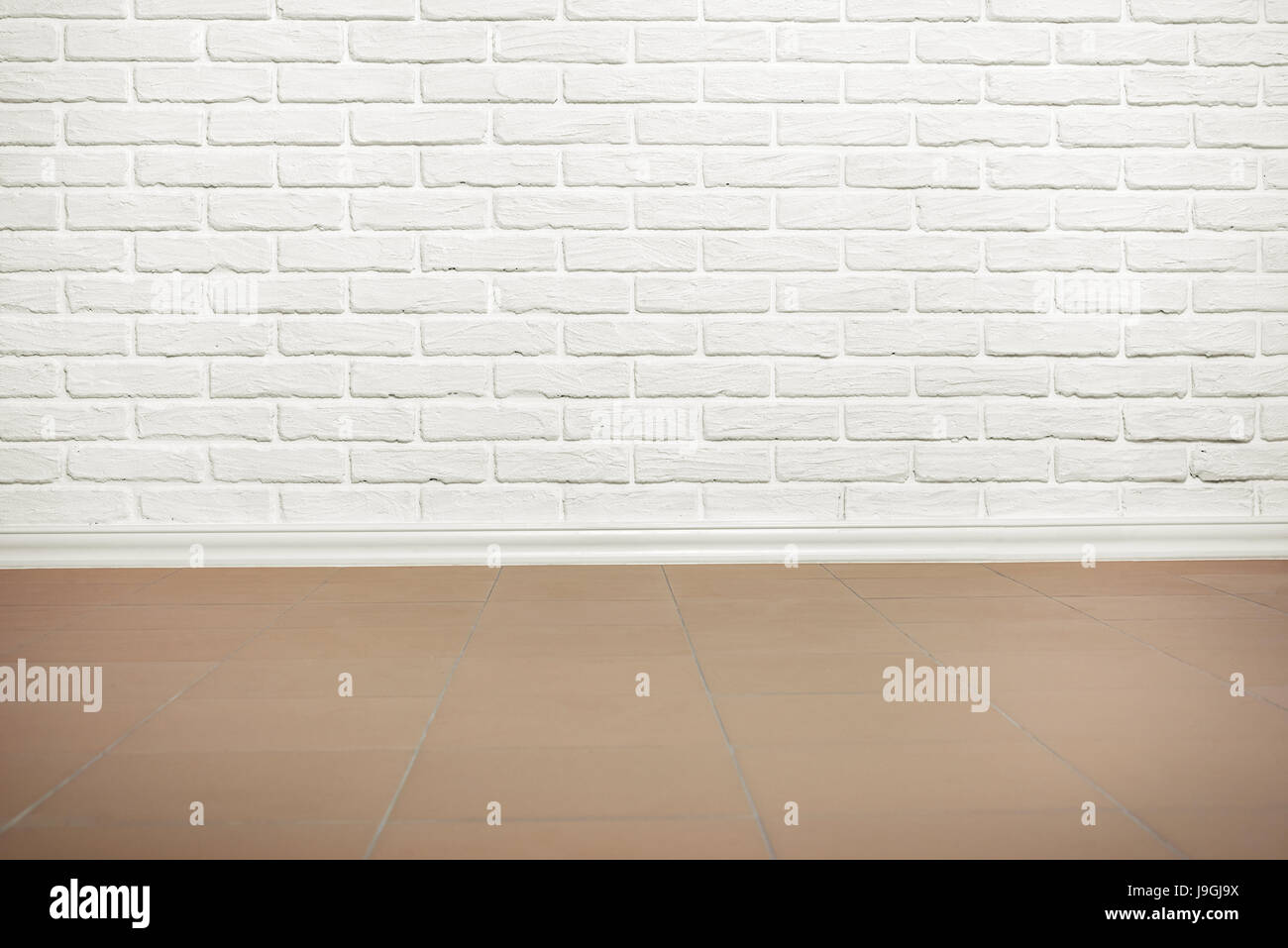 white brick wall with tiled floor, abstract background photo Stock