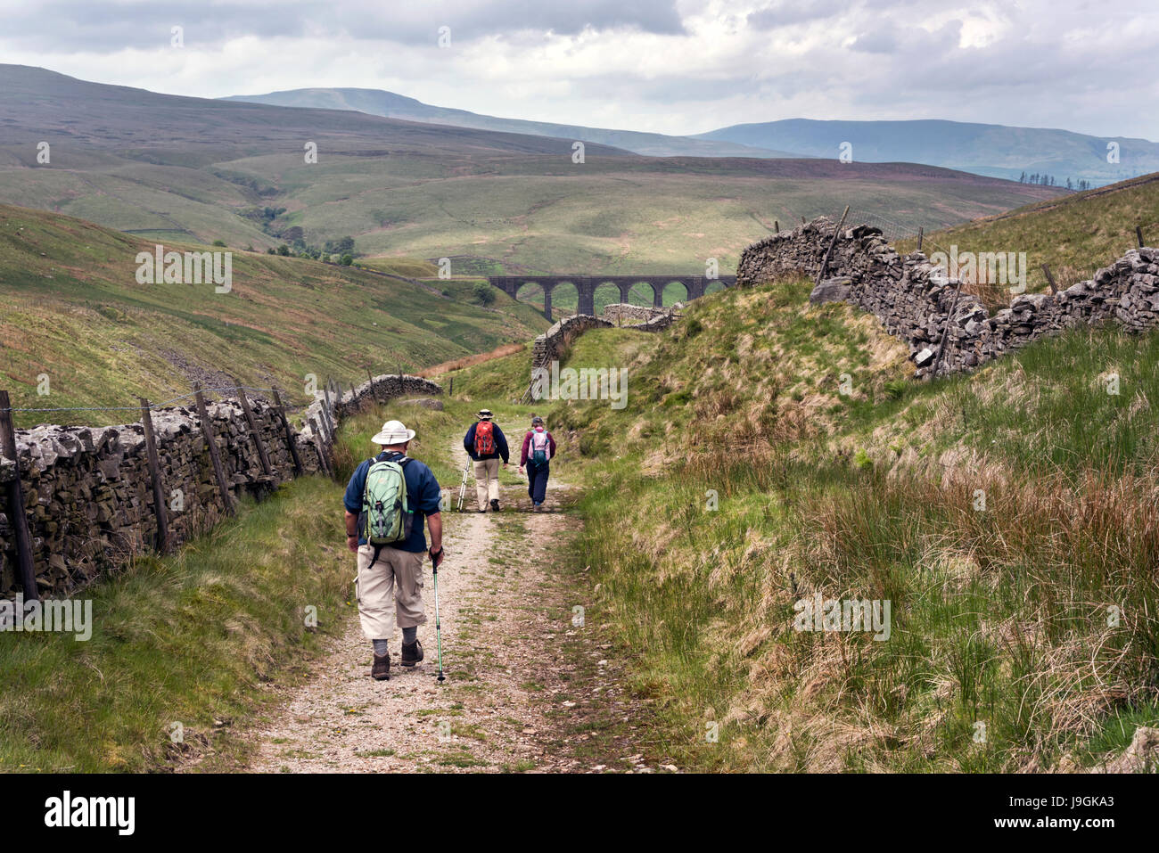 Walkers on an old drovers road, now the Pennine Bridleway, at Arten Gill. Dentdale, Yorkshire Dales National Park, UK Stock Photo