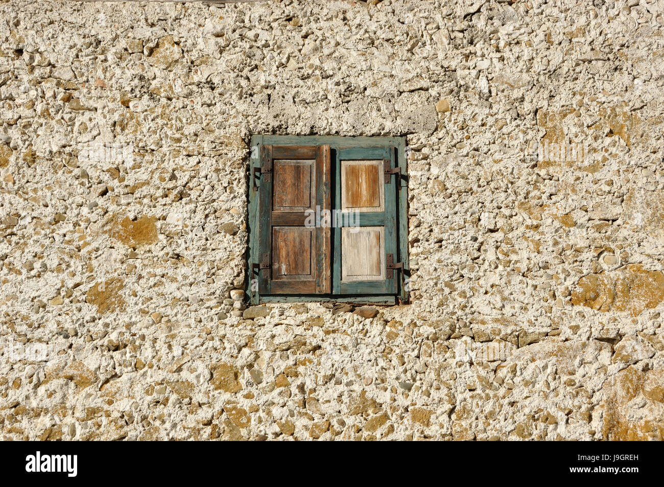 Bruchsteinwand mit Fenster mit geschlossenen Holz Fensterläden Stock Photo