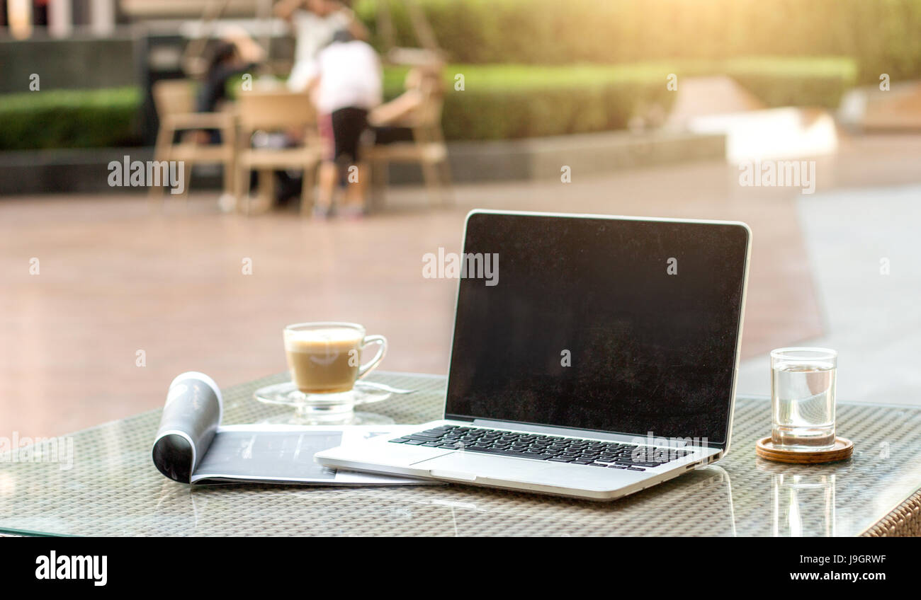 select focus blank mornitor for copy space laptop on table with mobile phone magazine and drink unplug freelance work life Stock Photo