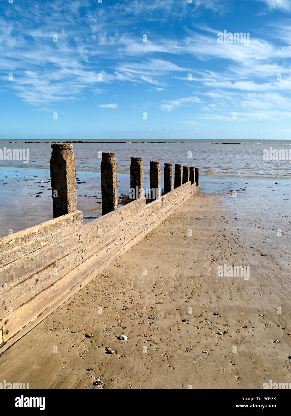 Wooden groyne on Eastbourne Beach with English Channel Sea and blue sky above, Eastbourne, East Sussex, England, UK Stock Photo