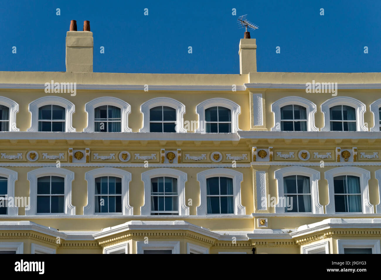 Ornate architectural detailing around windows of top floor of Mansion Lions Hotel, Grand Parade, Eastbourne, East Sussex, England, UK Stock Photo