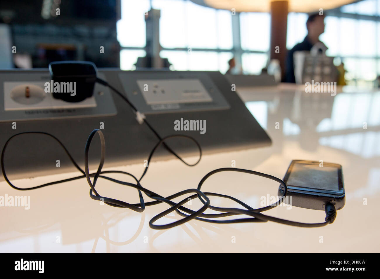 Phone charging on a table at charging station in the lobby. Free