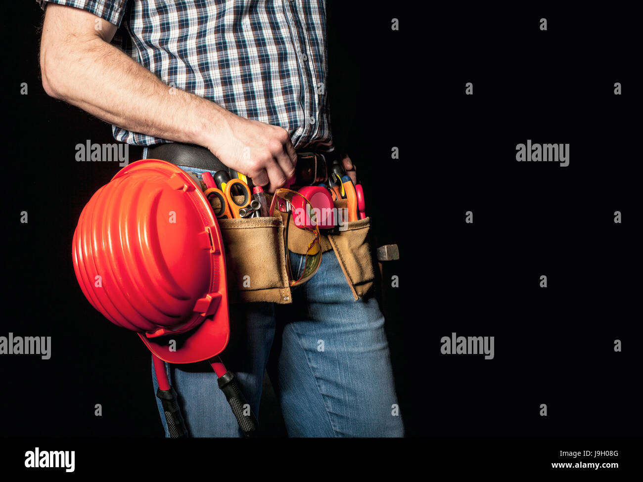 detail of handyman with leather toolsbelt and tools on dark background Stock Photo