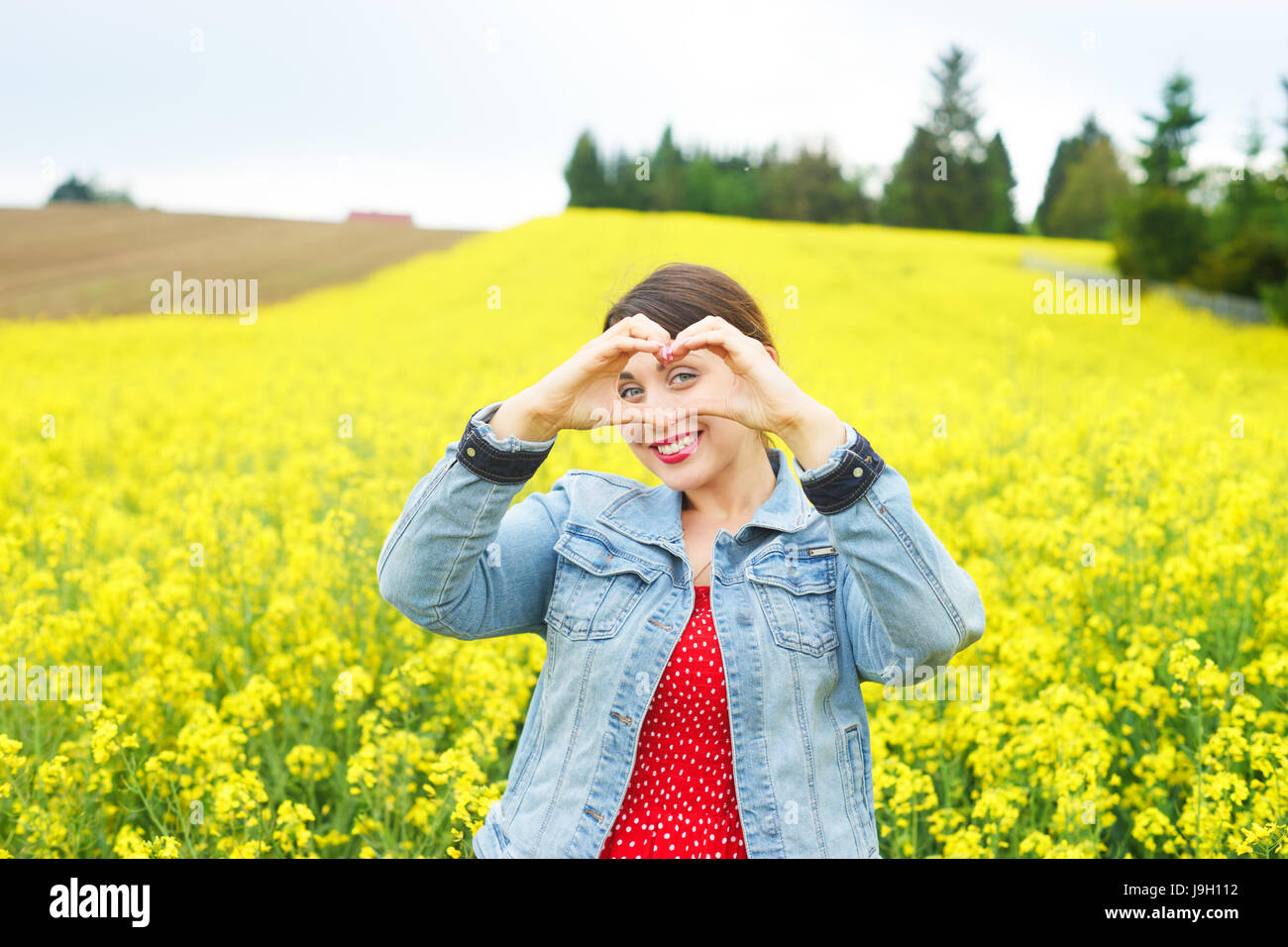 A young woman in rapeseed field Stock Photo - Alamy