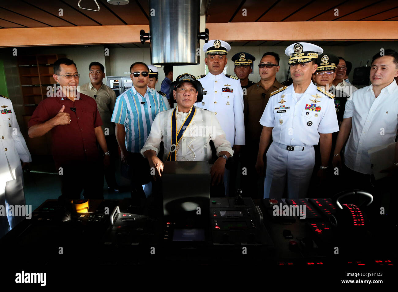 Philippine President Rodrigo Duterte sits at the helm of the newly-commissioned warship BRP Davao del Sur as Commander of the Philippine Navy Vice Adm. Ronald Mercado, right, looks on during the 119th Anniversary Celebration of the Philippine Navy at the Sasa Wharf May 31, 2017 in Davao City, Mindanao, Philippines. Earlier in a speech Duterte called to eradicate the emergence of violence extremists in the country as the government battles ISIS forces in Marawi City in Mindanao. Stock Photo