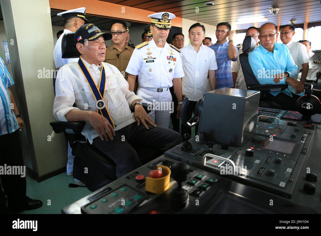 Philippine President Rodrigo Duterte sits at the helm of the newly-commissioned warship BRP Davao del Sur as Commander of the Philippine Navy Vice Adm. Ronald Mercado, center, looks on during the 119th Anniversary Celebration of the Philippine Navy at the Sasa Wharf May 31, 2017 in Davao City, Mindanao, Philippines. Earlier in a speech Duterte called to eradicate the emergence of violence extremists in the country as the government battles ISIS forces in Marawi City in Mindanao. Stock Photo