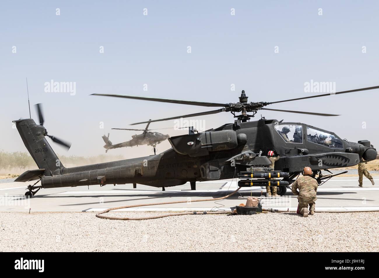 U.S. Army AH-64E Apache attack helicopters assigned to Task Force Griffin, 16th Combat Aviation Brigade, reloads weapons and fuel before departing on a mission in support of Operation Resolute Support May 31, 2017 in Kunduz, Afghanistan. Kunduz has seen increased Taliban activity as more than 8,000 American troops and 6,000 from NATO and allied countries continue to assist the government. Stock Photo
