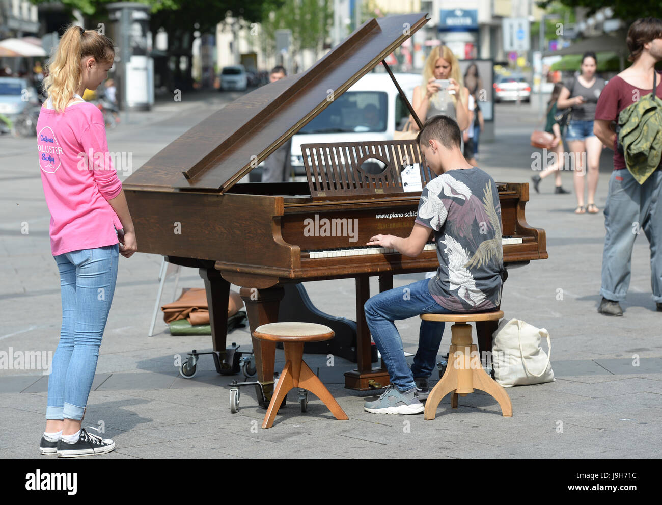 Stuttgart, Germany. 02nd June, 2017. A young man plays on the grand piano on the Königstraße in Stuttgart, Germany, 02 June 2017. At the action 'Open Piano For Refugees' pedestrians can play the piano. The collected money will be supporting music projects for refugees. Photo: Franziska Kraufmann/dpa/Alamy Live News Stock Photo