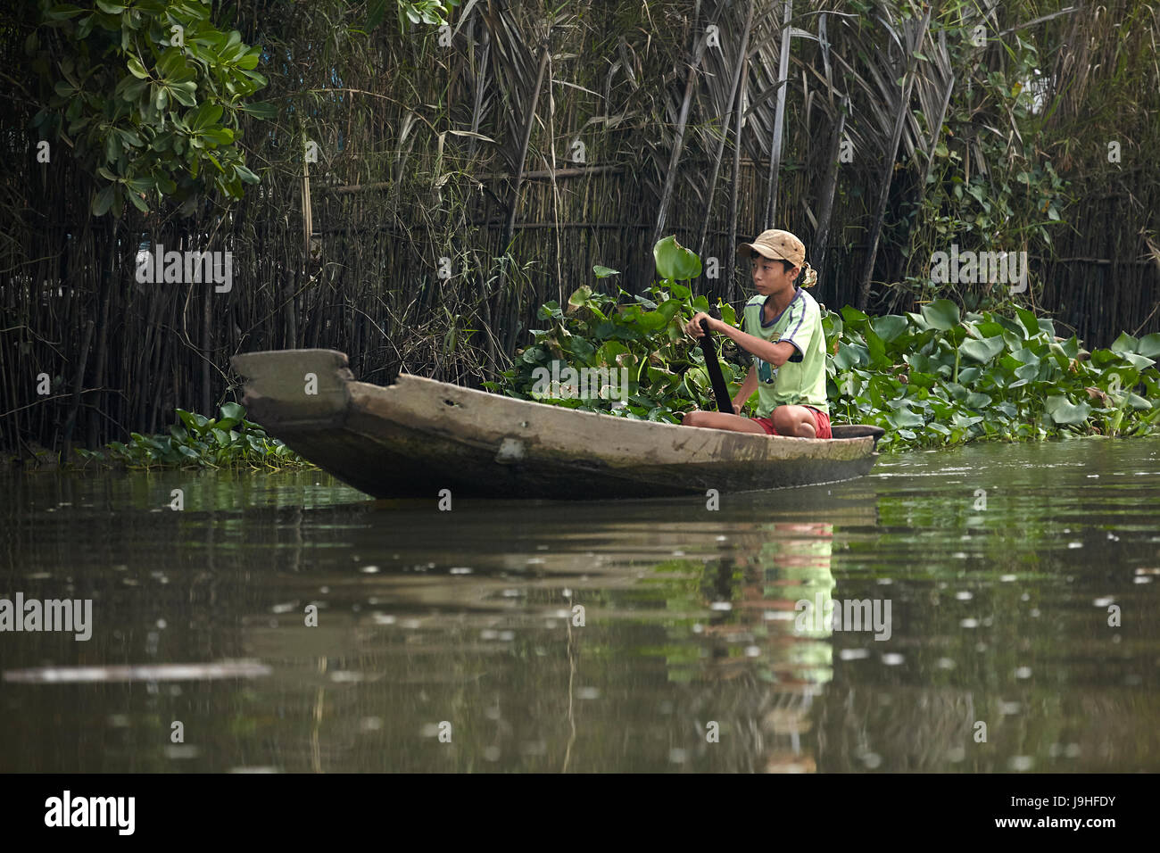 Boy in wooden boat, Can Tho River, near Can Tho, Mekong Delta, Vietnam ...