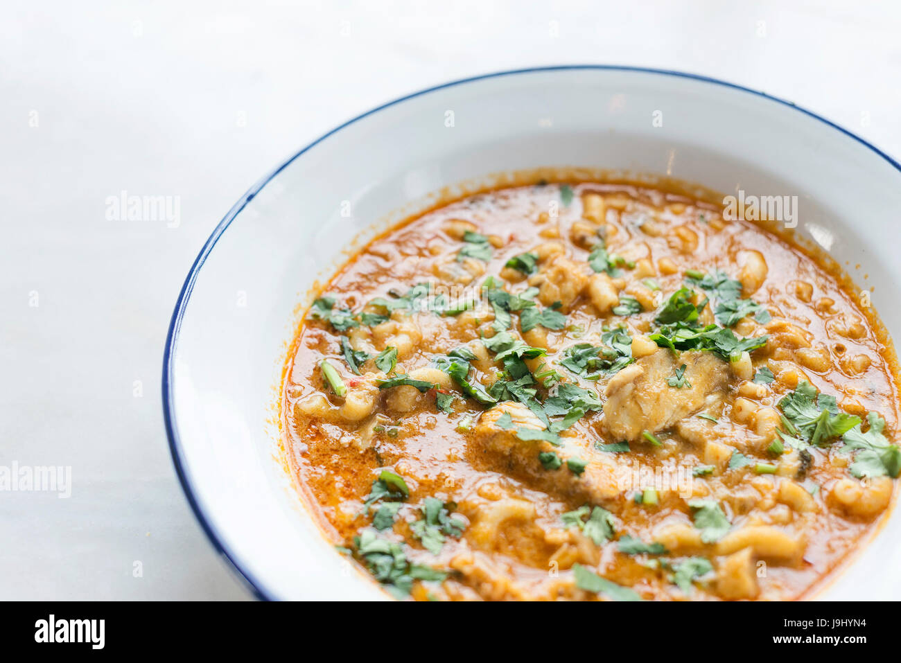 creamy spicy seafood fish soup with coriander herbs Stock Photo