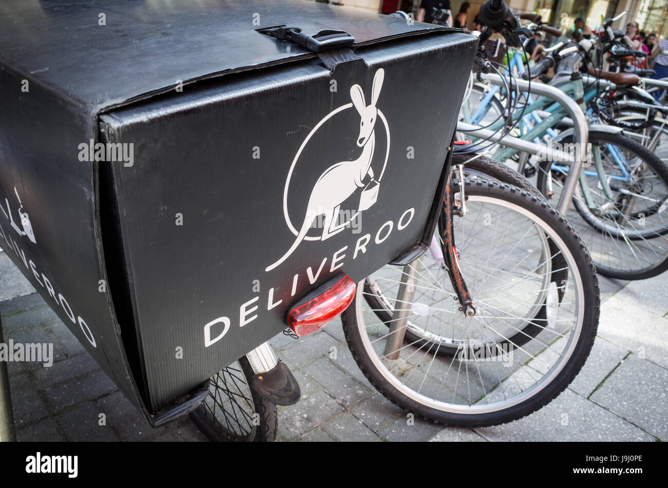 A Deliveroo box on the rear of a food delivery courier bike in London UK. Fast Food delivery buy bike courier is a fast growing part of the UK economy. Stock Photo