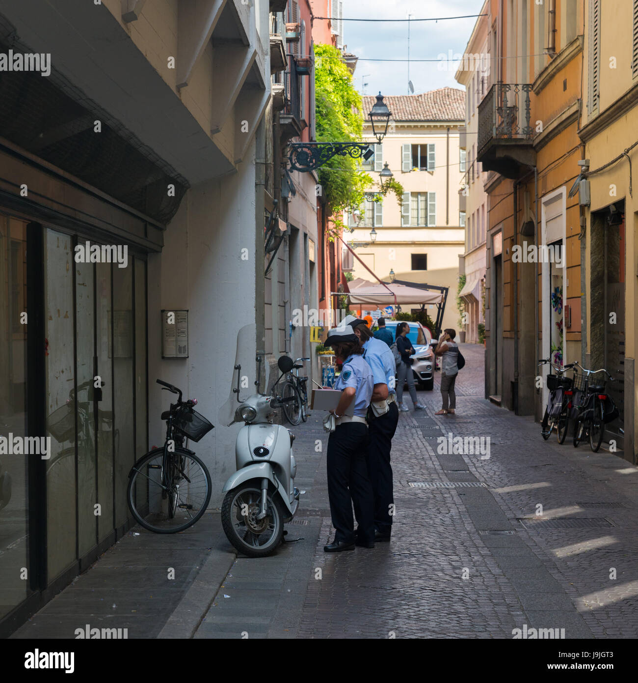 traffic police (Carabinieri)  in Parma, Italy make a report on a vespa in an alleyway Stock Photo