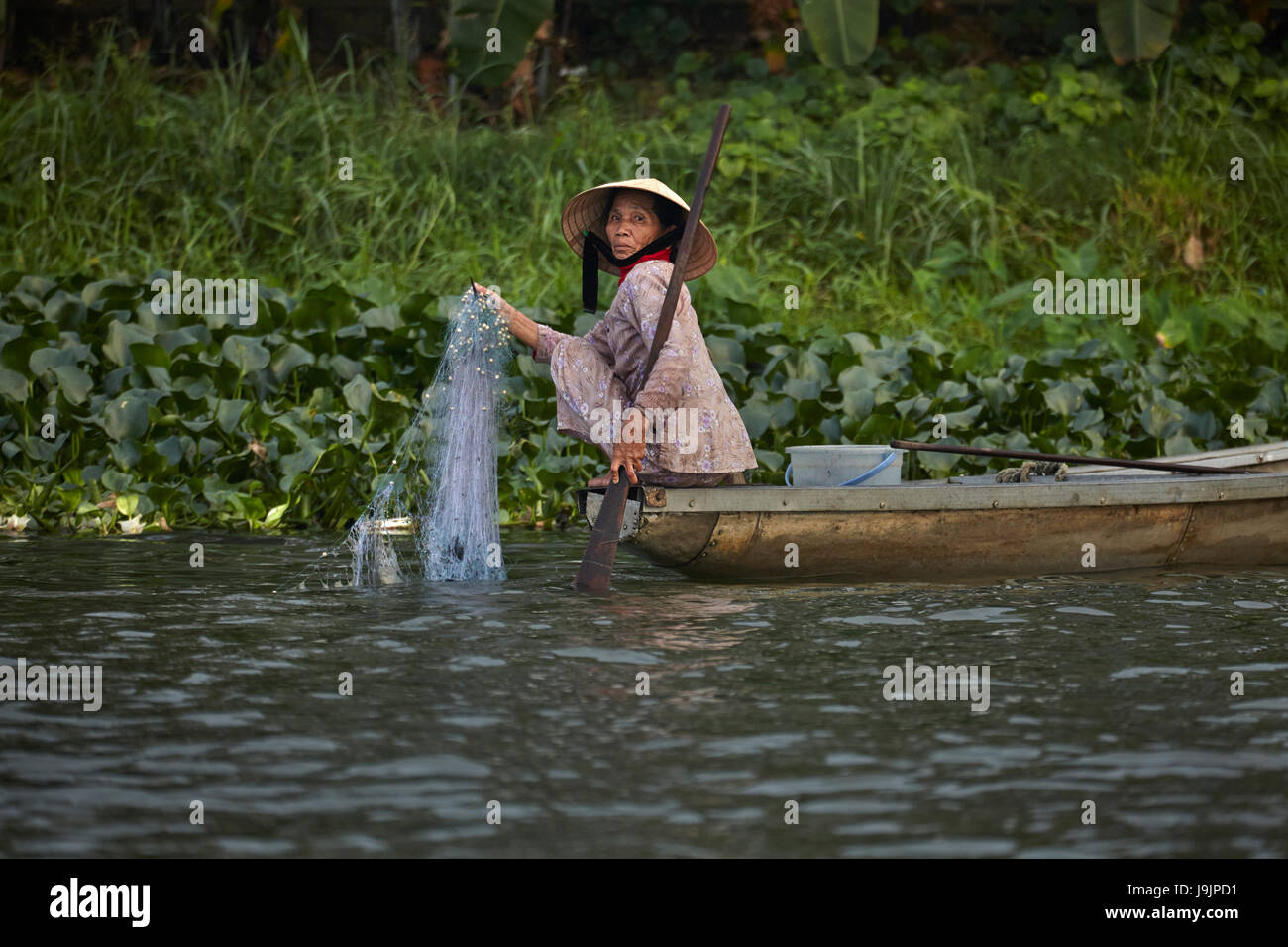 Woman fishing from boat on Perfume River, Hue, North Central Coast, Vietnam Stock Photo