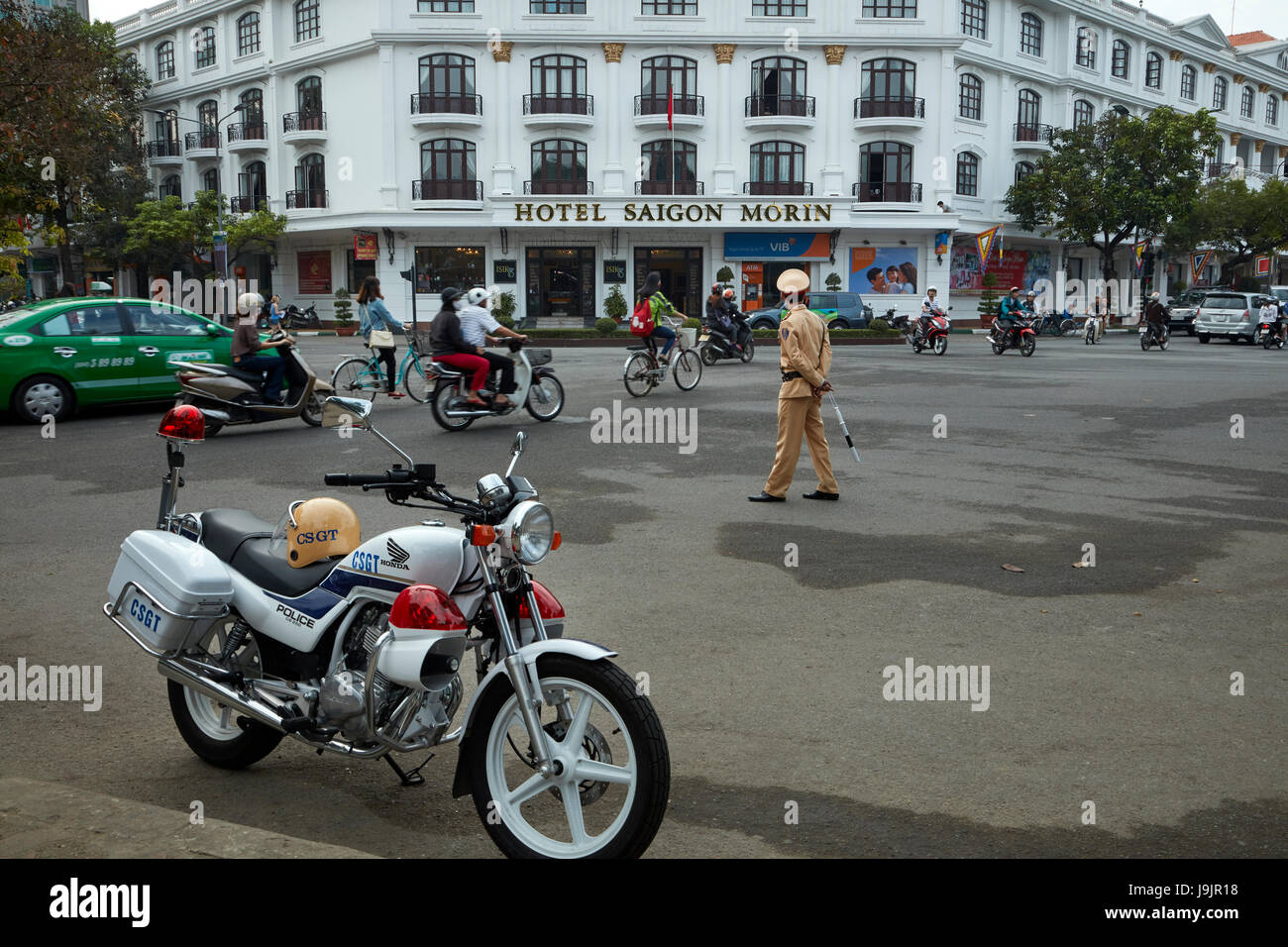 Police motorcycle, busy intersection, and Hotel Saigon Morin, Hue, North Central Coast, Vietnam Stock Photo