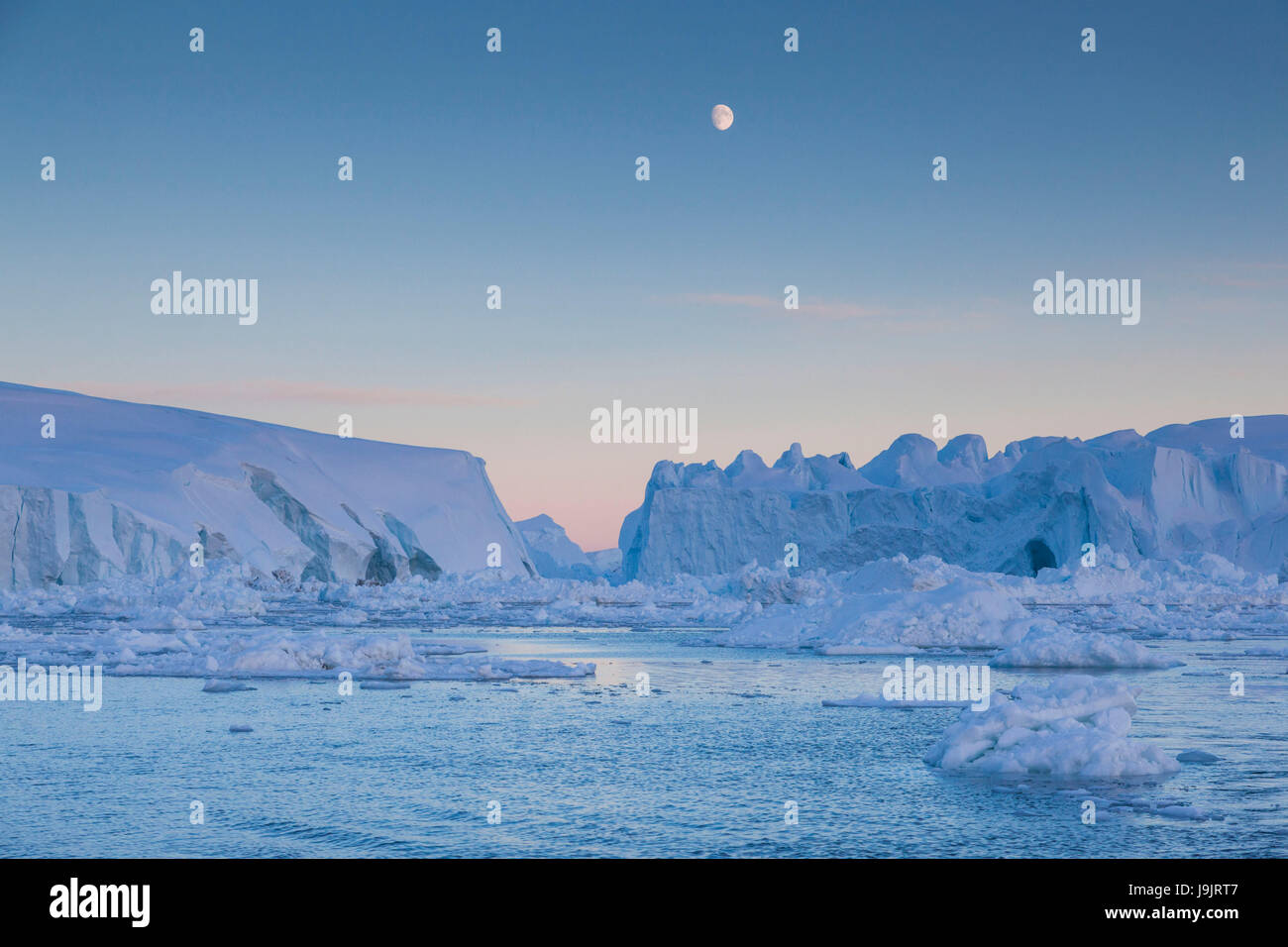 Greenland, Disko Bay, Ilulissat, floating ice at sunset with moonrise ...