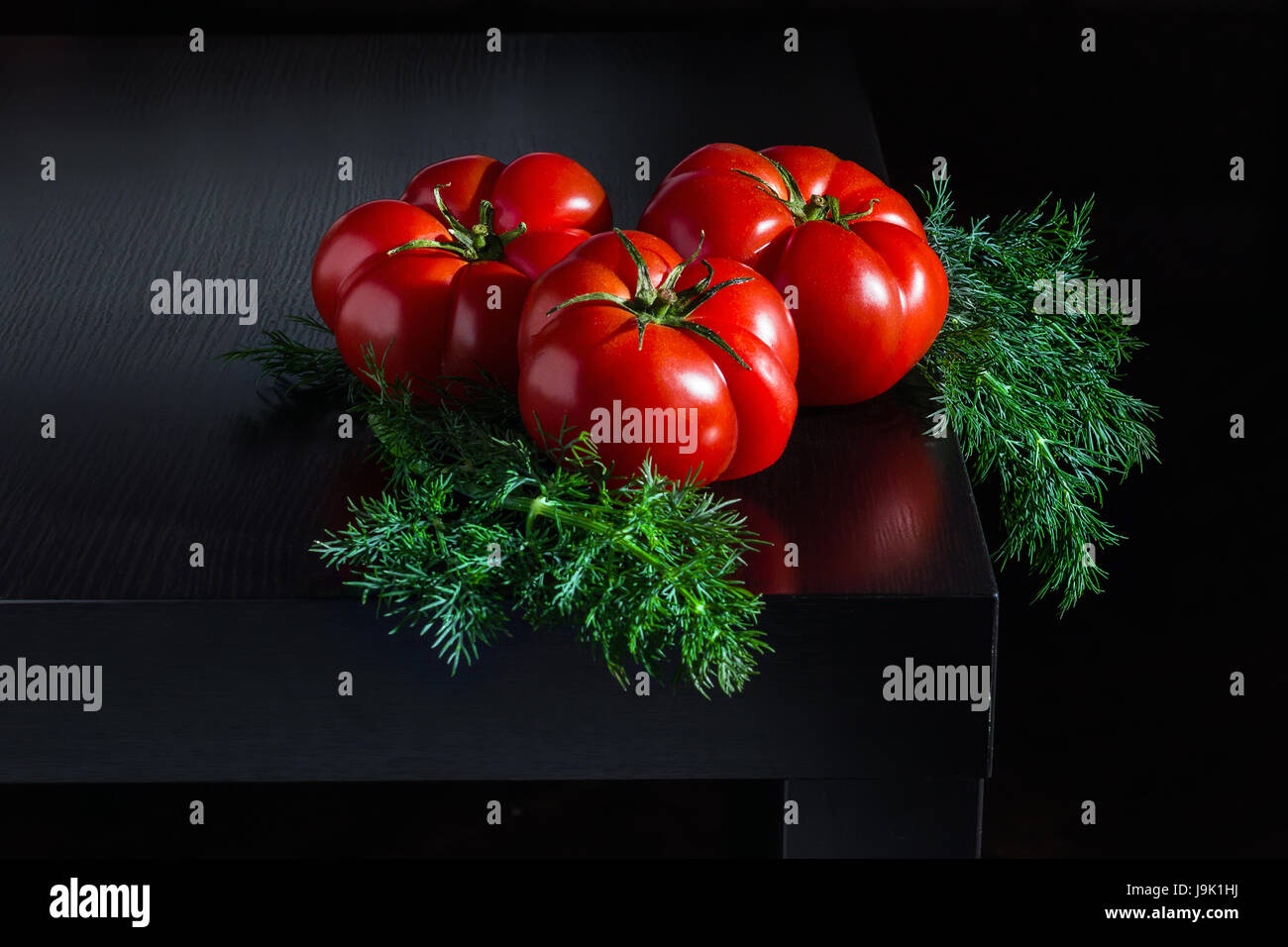 Juicy tomatoes with dill on a wooden dark background Stock Photo - Alamy