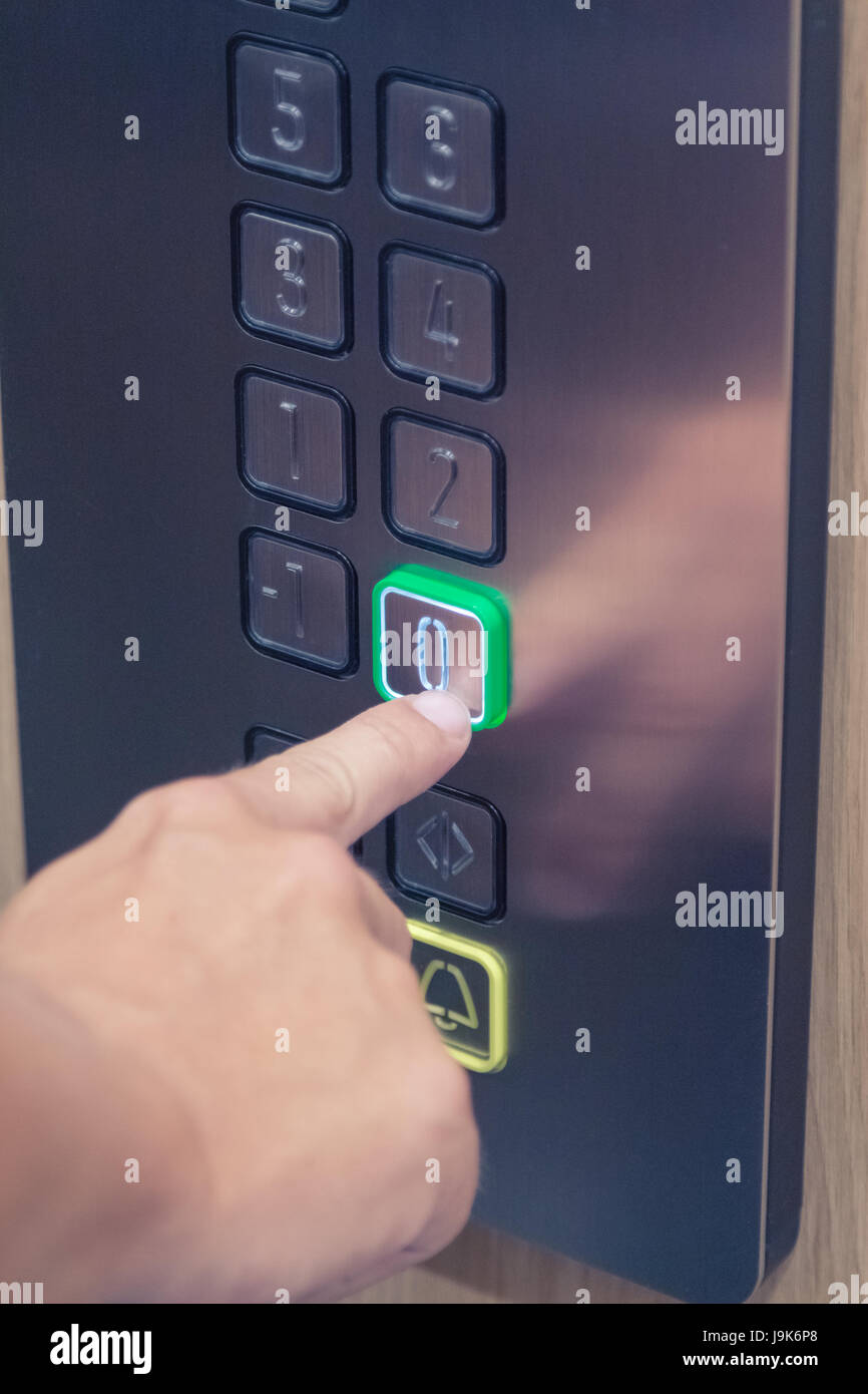 Man pressing the button in the elevator interior Stock Photo