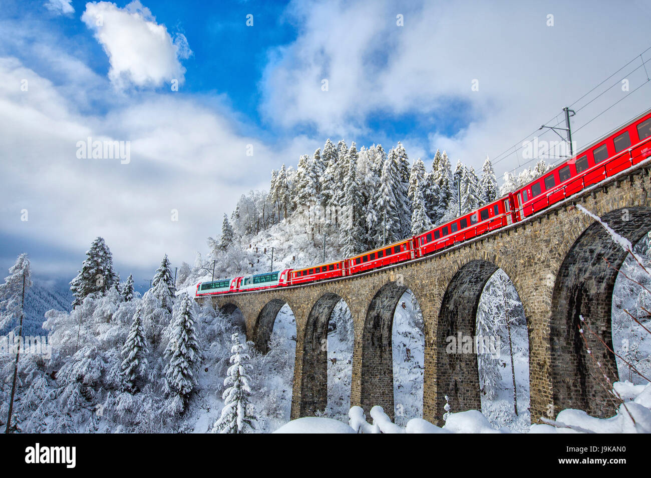 Filisur Pass Bernina Express passes through the snowy woods around Filisur Canton of ...