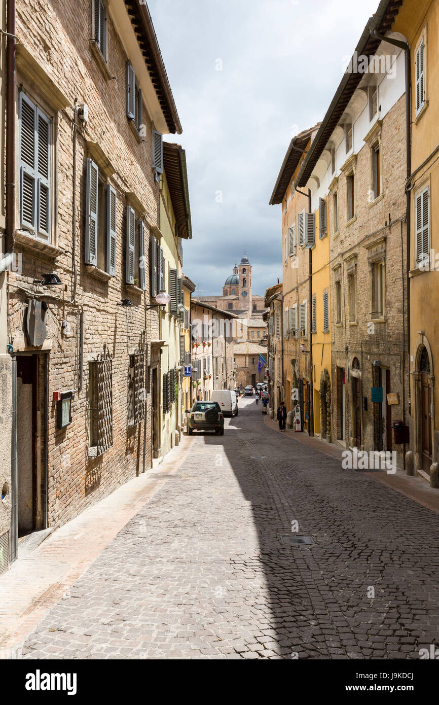 A medieval alley of the hill town with Piazza Duca Federico on the background Urbino Province of Pesaro Marche Italy Europe Stock Photo