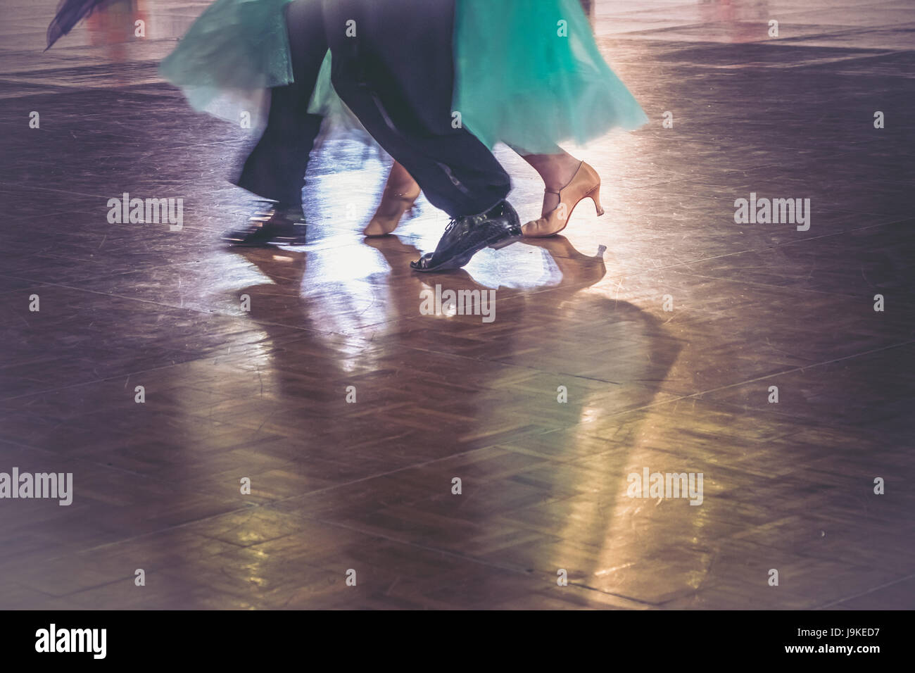 Motion blur of couple dancers in a dance spotlight on the floor, during Grand Slam Standard dance. Stock Photo
