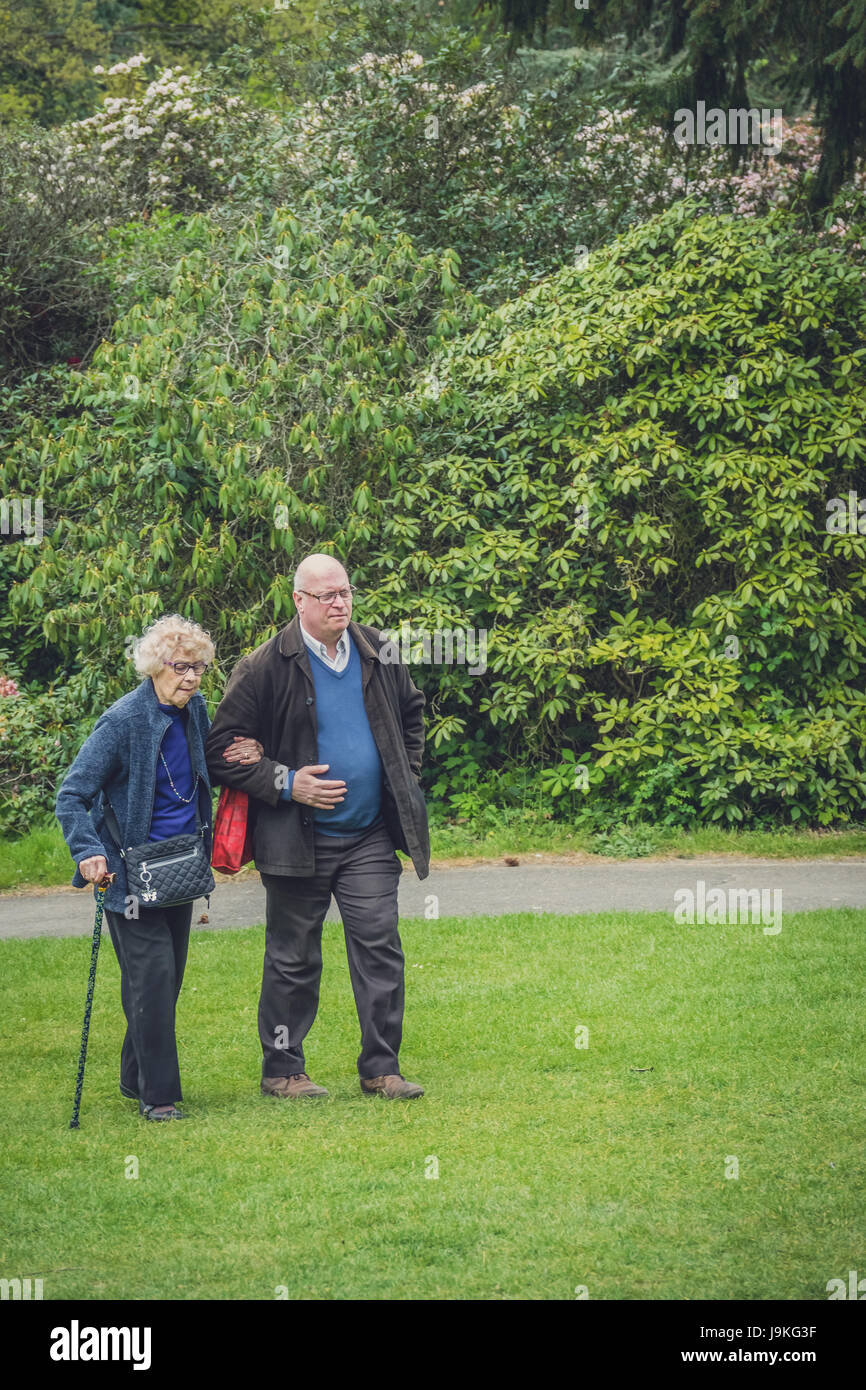 Hever Castle, England -  April 2017 : Middle aged caucasian man walking in the garden with his old mother Stock Photo
