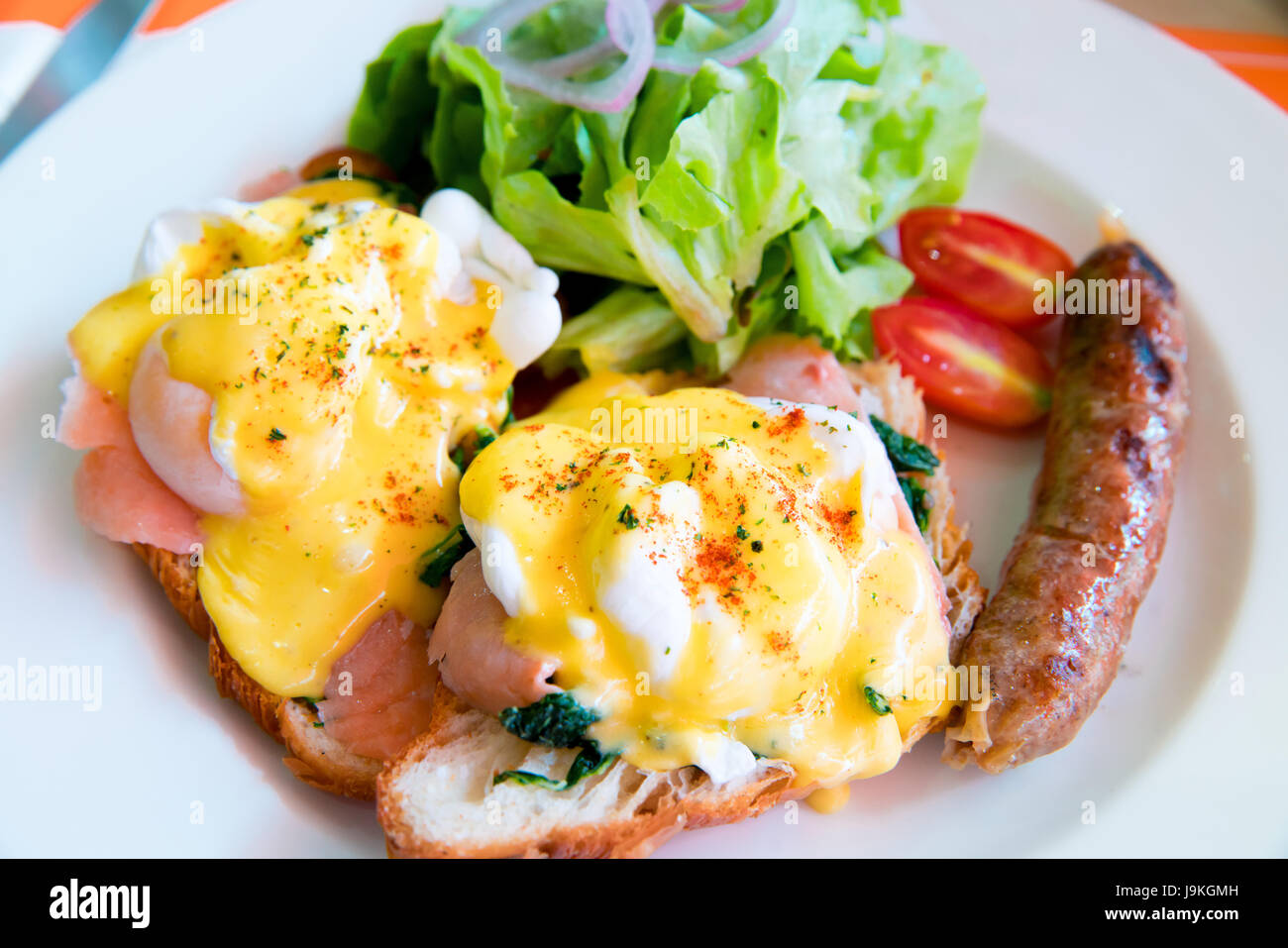 Egg benedict with smoked salmon, sauce, green salad vegetable and grill hot dog Stock Photo