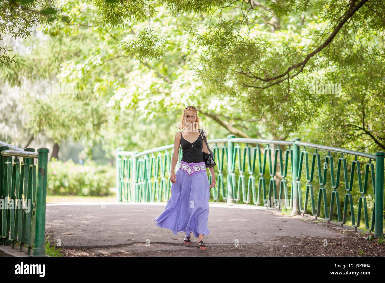 Happy woman walking in summer park smiling Stock Photo - Alamy
