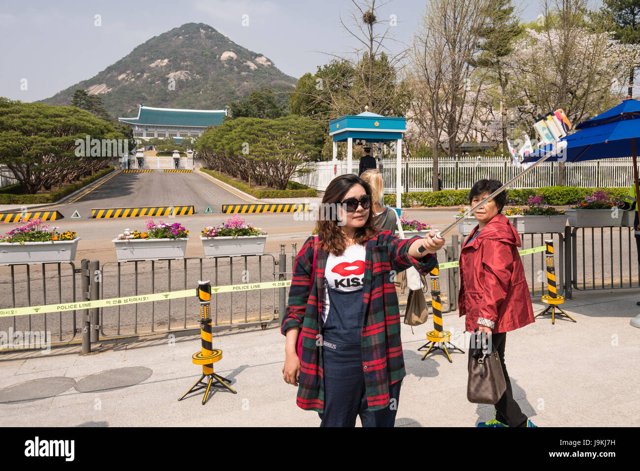 A female tourist taking selfie with Korean Presidential Residence (The Blue House) in the background, Seoul, South Korea Stock Photo