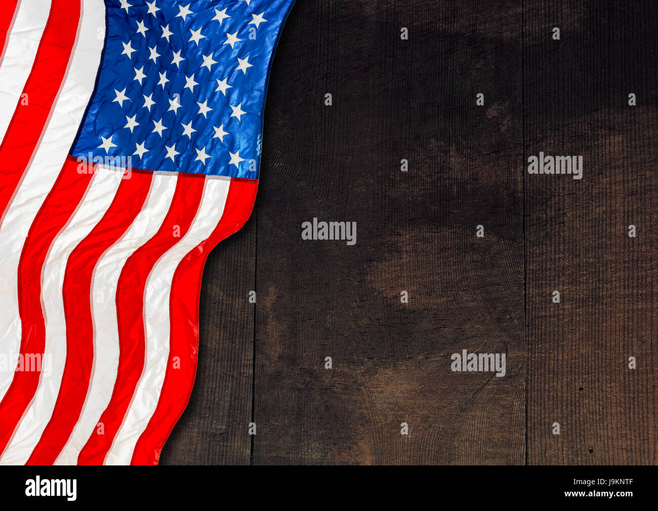 National flag of the United States of America, on a dark wooden table top with plenty of copy space. Stock Photo