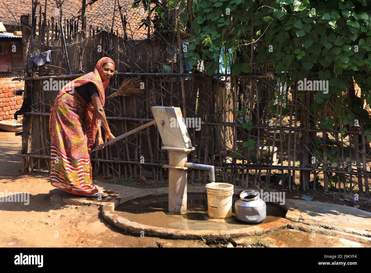 woman pumping hand pump, Gujrat, India, Asia Stock Photo