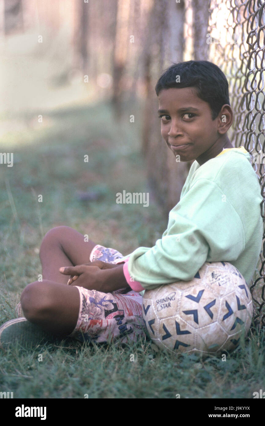 boy sitting with football Cooperage Football Ground Mumbai Maharashtra India Asia Stock Photo