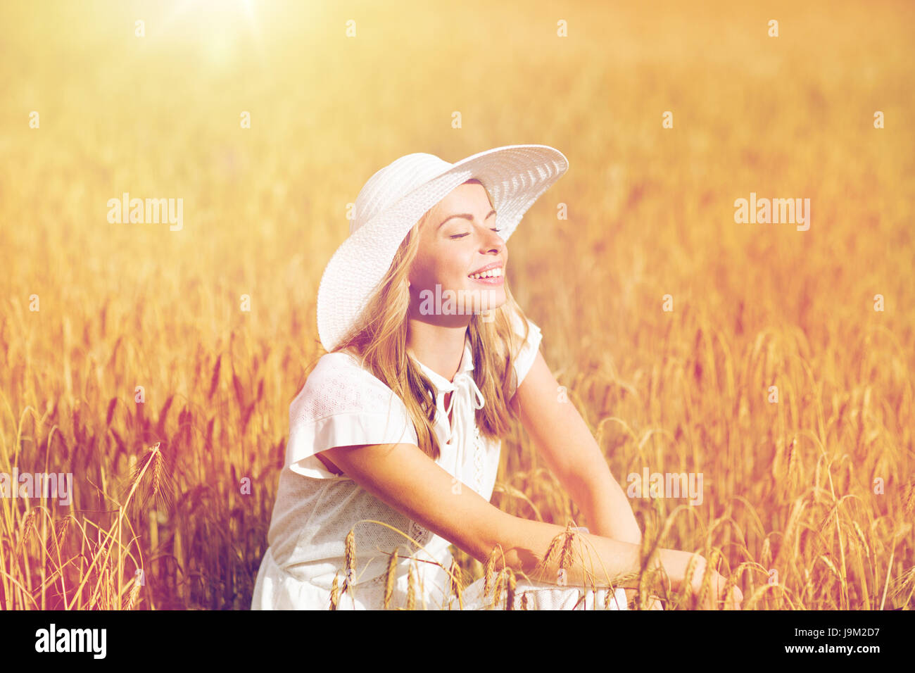 happy young woman in sun hat on cereal field Stock Photo - Alamy