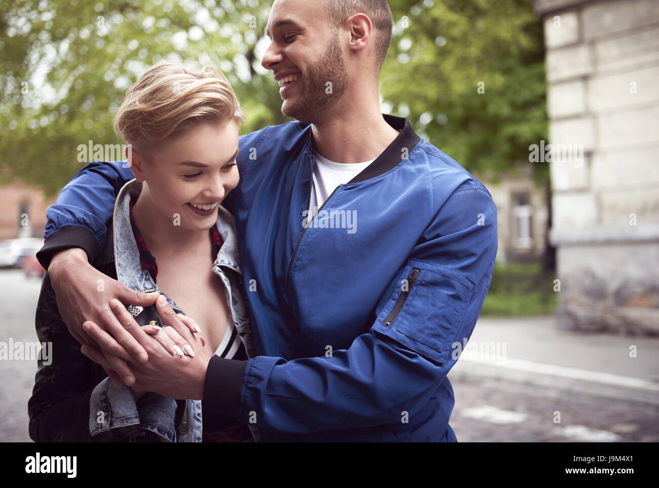 Waist up of young couple embracing in the city Stock Photo