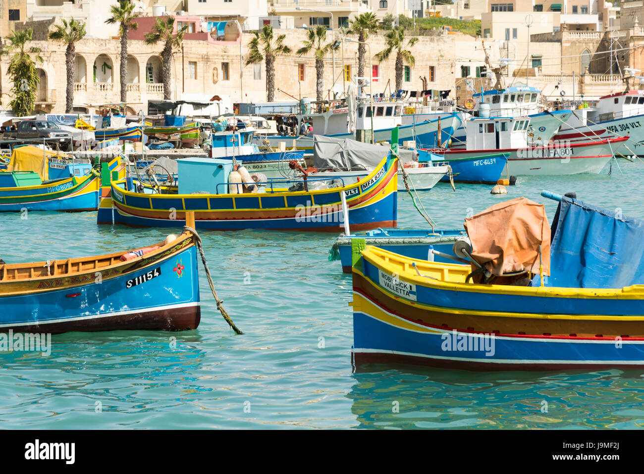 The Carmelo Padre a traditional Maltese fishing boat or luzzu, brightly painted in the harbour of Marsaxlokk in Malta Stock Photo