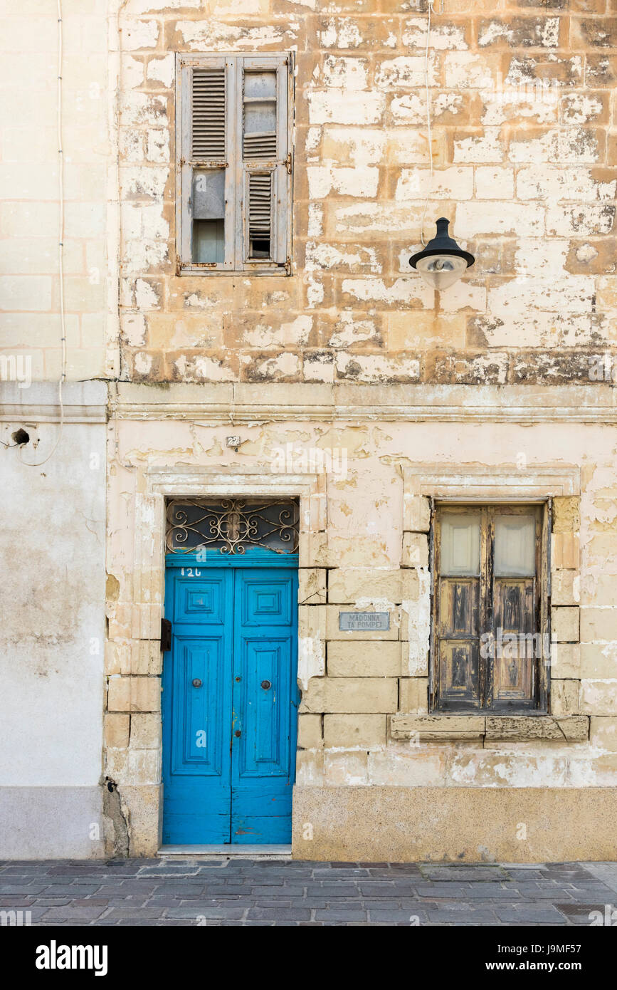 A brightly painted blue door on an old stone building in Malat Stock Photo