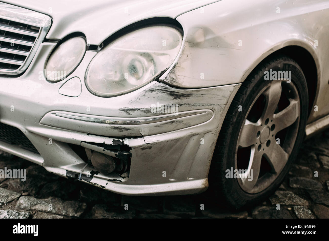 Broken Bumper Luxury Car Scratched With Deep Damage To Paint. Abandoned Car After Accident In City Street Stock Photo