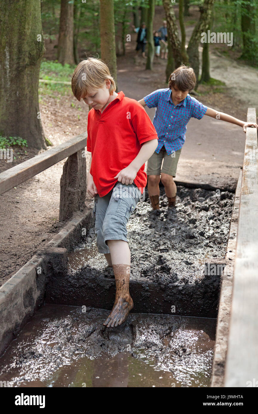 boys walking through mud at barefoot trail Egestorf Lower Saxony