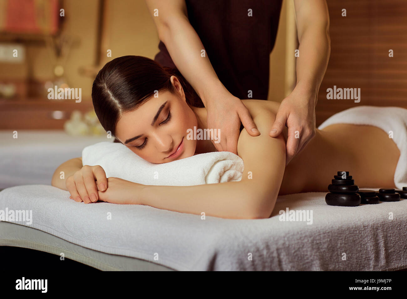 Young woman doing massage in spa salon. Stock Photo