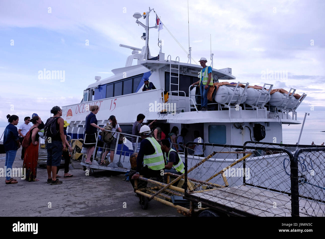 Tourists board a ferry at the port of the city of Siquijor at the island of Siquijor located in the Central Visayas region of the Philippines Stock Photo