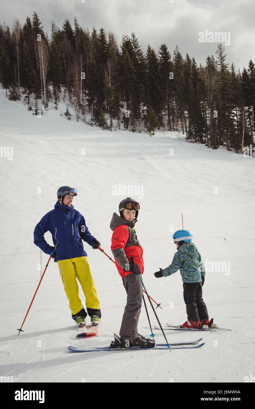 Father and kids skiing on snowy alps during winter Stock Photo