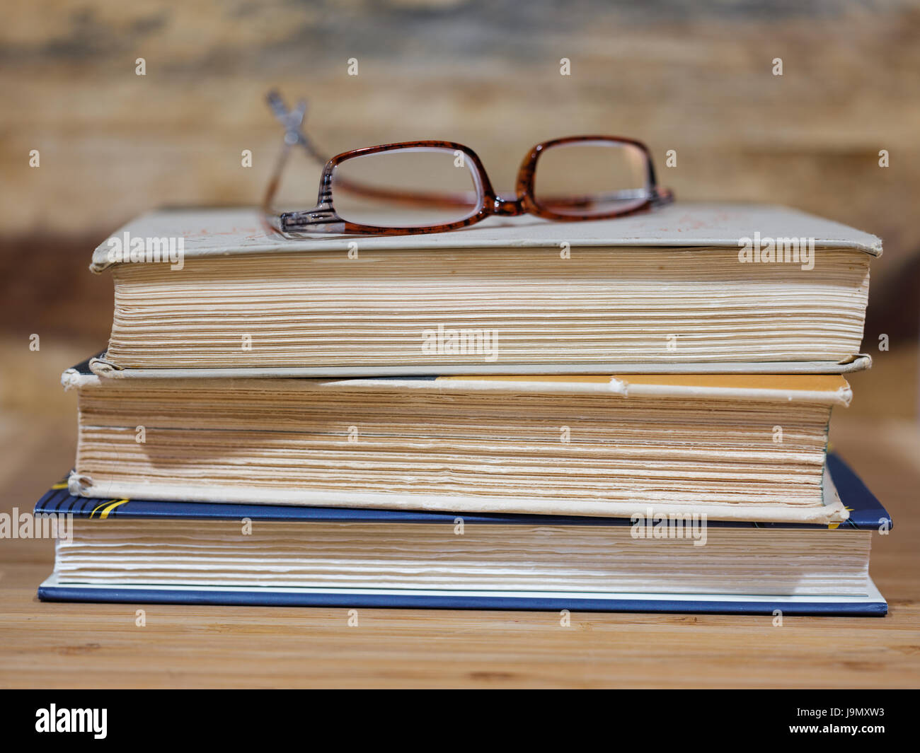 Three books with reading glasses Stock Photo - Alamy