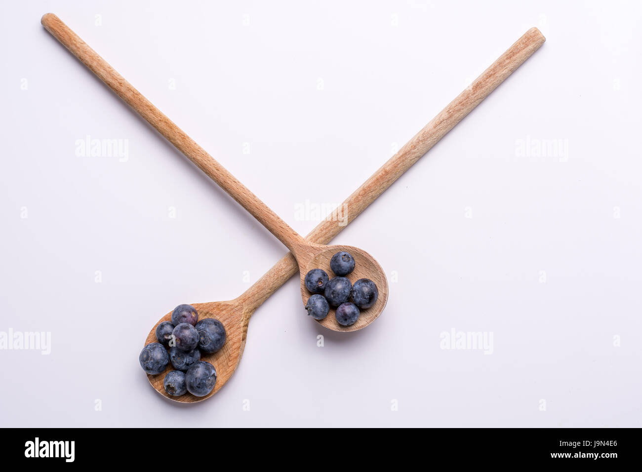 Blueberries on wooden spoon on white background Stock Photo