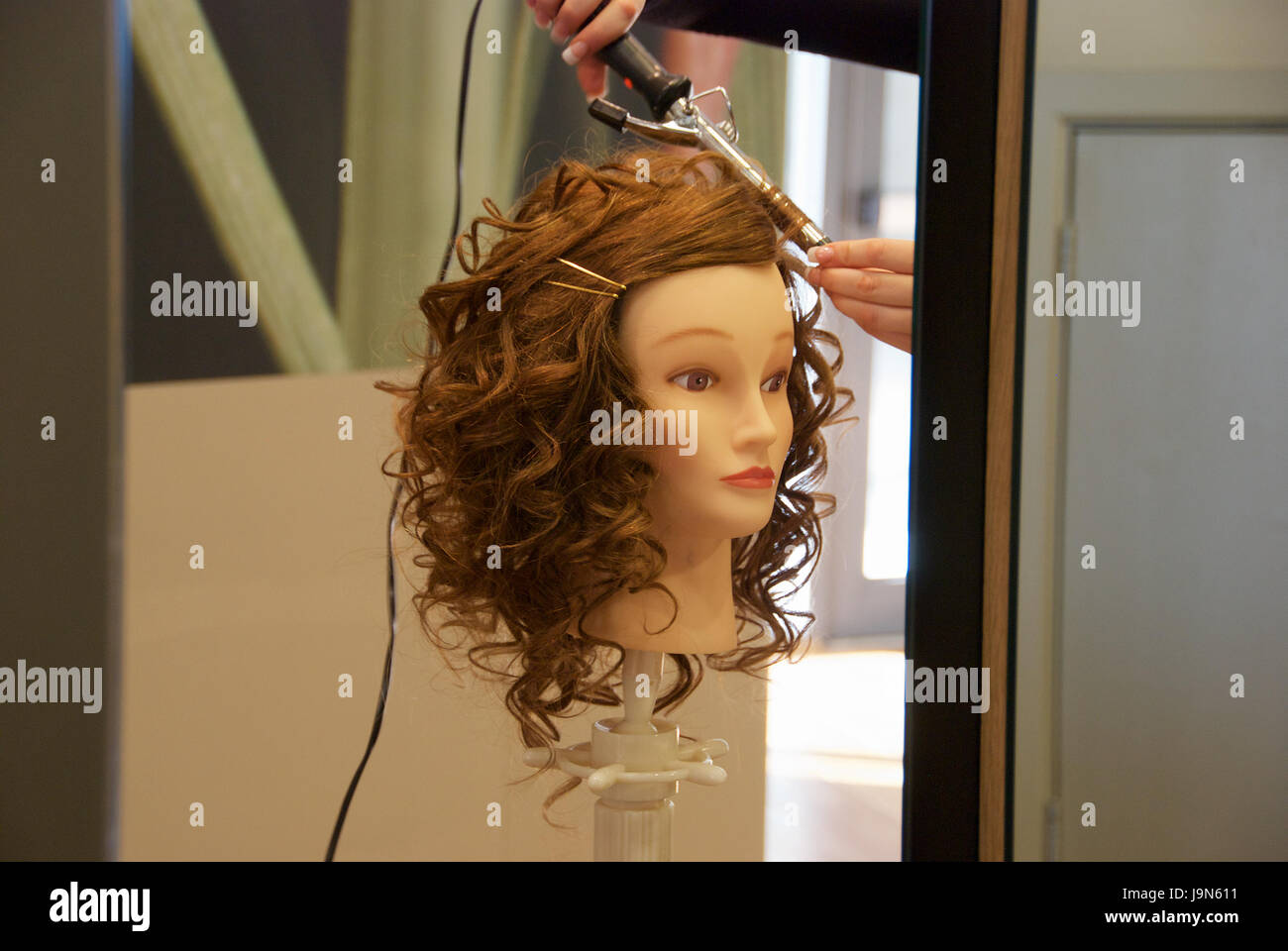 Hairstylist Working On A Wig On A Mannequin At A Lifestyle Salon