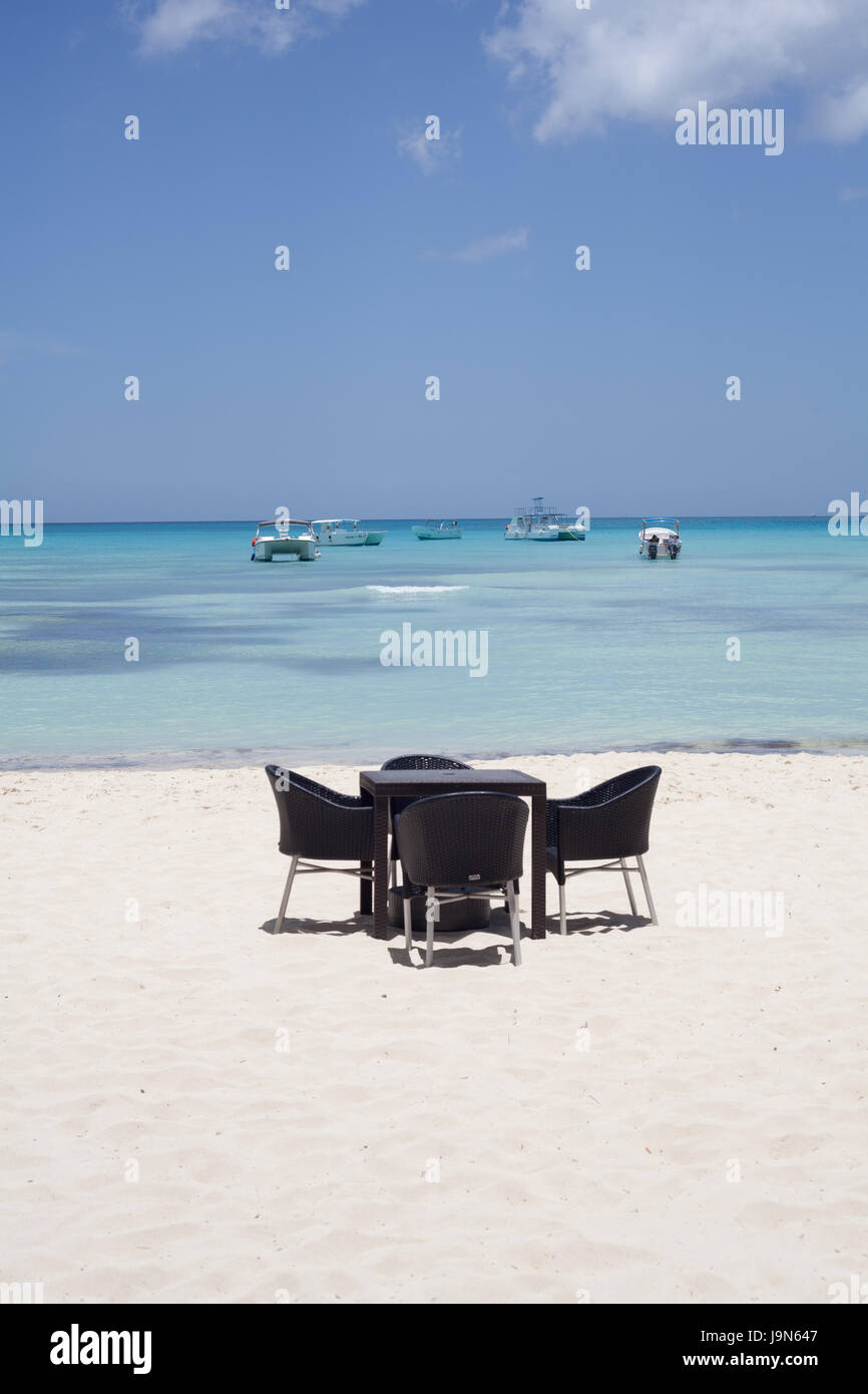 Table and chairs on a stunning beach on the Caribbean Island of Sanoa with its fine white sand and azure waters, Dominican Republic Stock Photo
