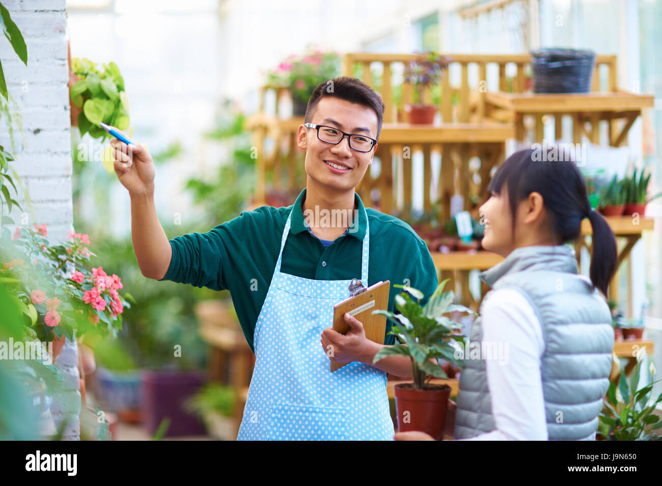 Young Asian Male Florist Have Conversation with his Customer in the Shop Stock Photo