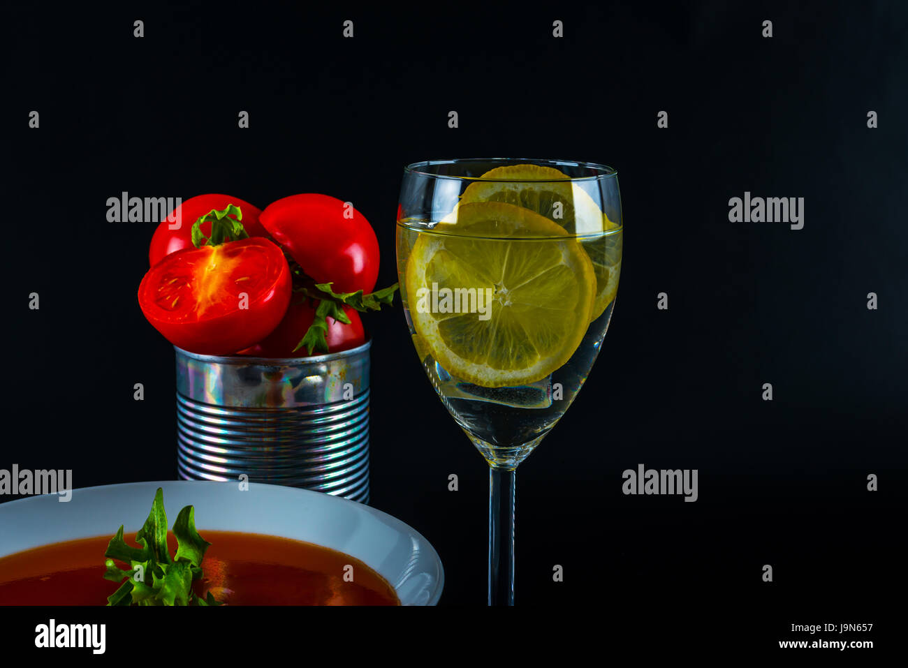 Tomato vegetarian soup with metal tin, fresh tomatoes, water with lemon