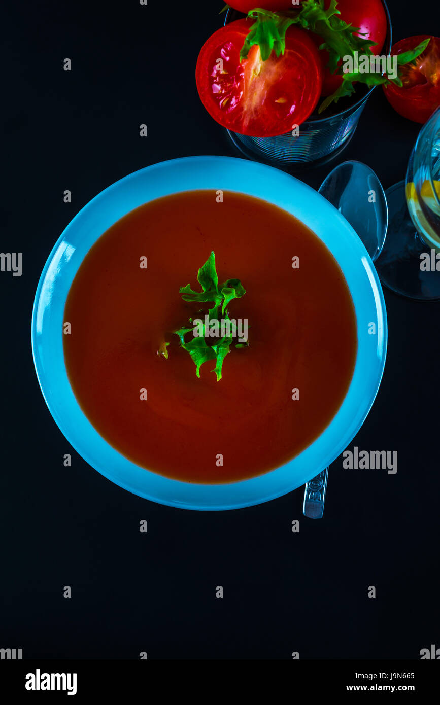 Tomato vegetarian soup with metal tin, fresh tomatoes, water with lemon