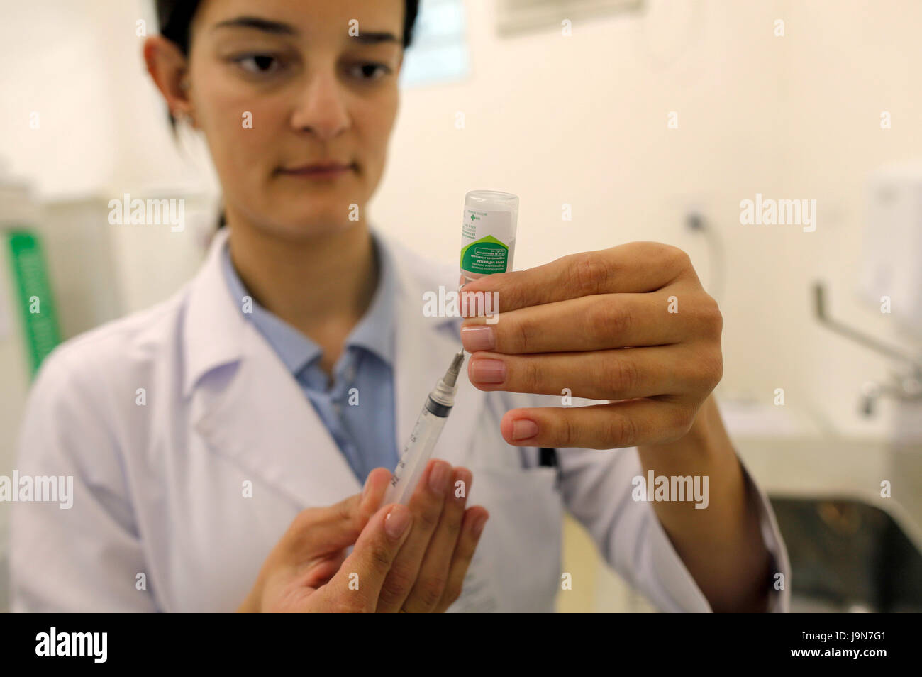 Nurse preparing a dose of vaccine against influenza - flu shot, in a public health office of Sao Paulo city - Brazil - South America Stock Photo