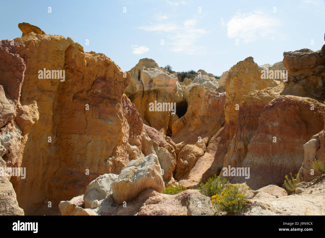 Cave entrance surrounded by colorful walls at Paint Mines Stock Photo